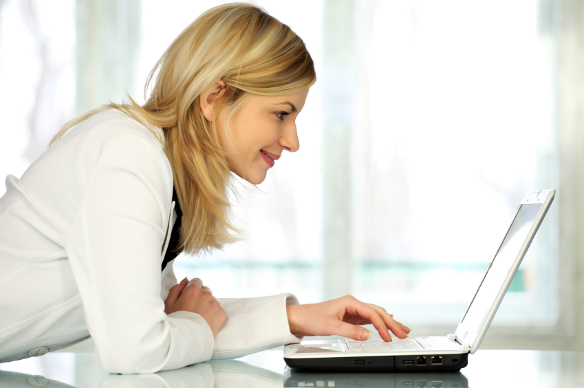 Woman typing on laptop computer.